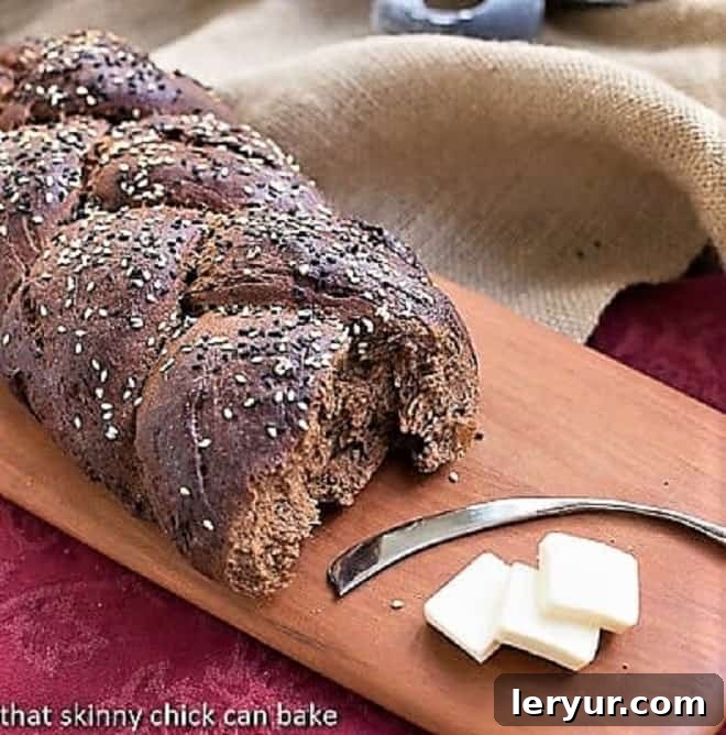 Rich, delicious Pumpernickel Loaves make a tasty breakfast, sandwich or dinner side! Pumpernickel Loaf on a wooden cutting board, ready to be sliced