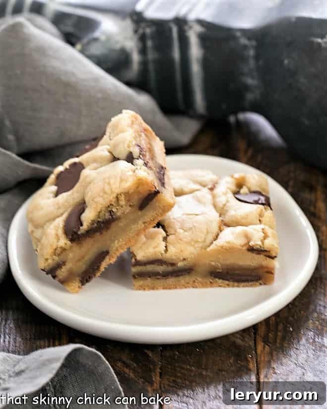 Caramel Chocolate Chip Cookie Bars - rich buttery cookie bars filled with chocolate and caramel sauce Two Caramel Chocolate Chip Cookie Bar on a small round white plate