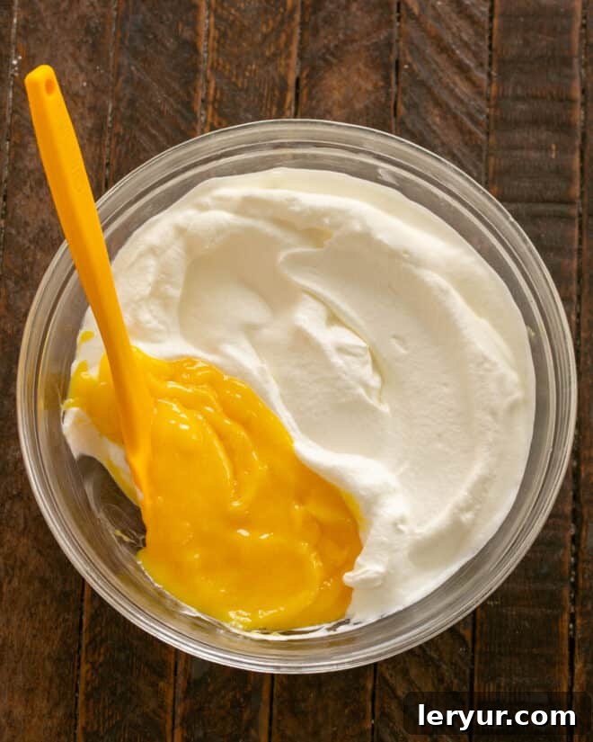 Holiday Ambrosia Salad 4 Adding the cooled lemon custard to freshly whipped cream, preparing the dressing.
