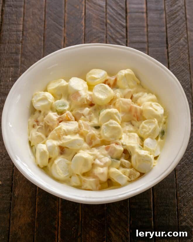 Holiday Ambrosia Salad 8 The fully mixed fruit salad with dressing, gently folded together and ready for chilling.