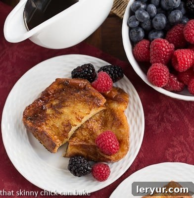 Sugar-Crusted French Toast - a double coating of sugar make this rich, eggy French toast dessert worthy! Overhead view of Sugar-Crusted French Toast on a white ceramic plate with fresh berries, highlighting the golden brown crust.