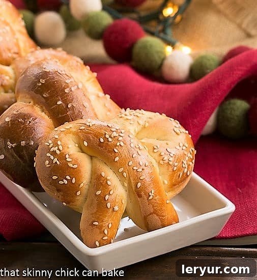 Homemade Challah Pretzels covered with sesame seeds on a white tray