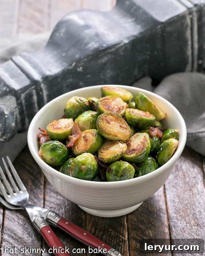 Brussels Sprouts with Bacon, Shallots and Garlic - A flavor packed Brussels sprouts recipe cooked on the stovetop A white bowl of skillet brussels sprouts with bacon and two red handled forks