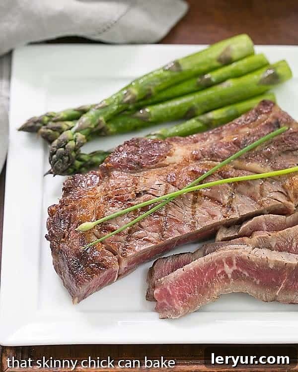 Perfectly Sliced Grilled Rib Eye Steaks on a square white plate, showing ideal medium-rare doneness.