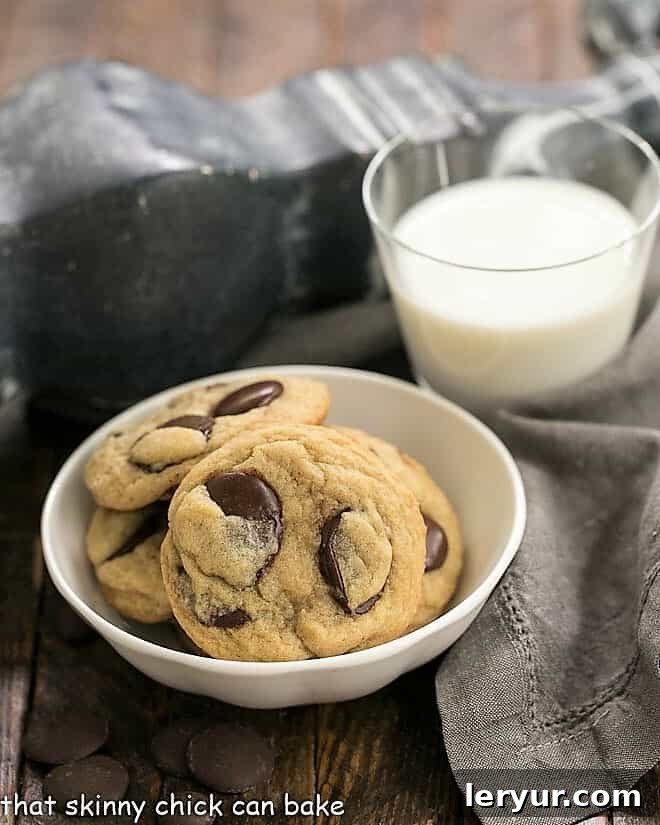 Southern Living's BEST Chocolate Chip Cookies - thick and chewy with loads of chocolate! A white bowl brimming with Southern Living's BEST Chocolate Chip Cookies, thick and perfectly golden, sits next to a refreshing glass of milk.