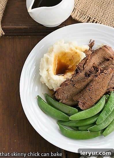 Perfectly cooked Coffee Glazed Brisket slices served with vibrant sugar snap peas and creamy mashed potatoes on a white plate, viewed from above.