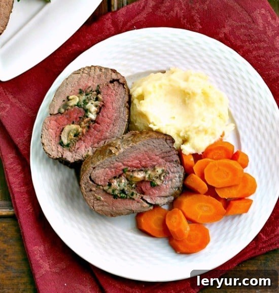 Gourmet Gorgonzola Mushroom Stuffed Tenderloin 2 Slices of Gorgonzola and Mushroom Stuffed Beef Tenderloin on a dinner plate, showcasing the vibrant filling and perfect doneness.