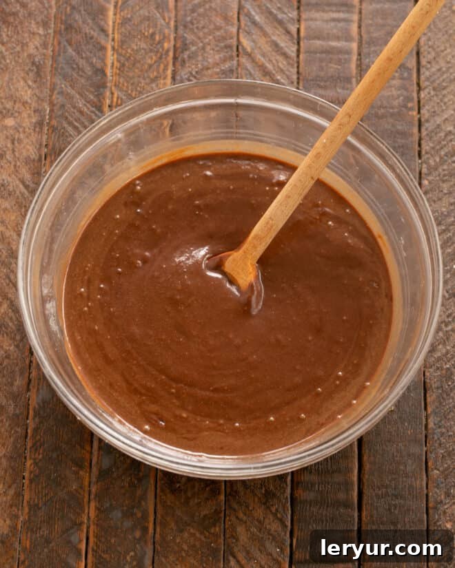 Hot water being poured into the fudge cake batter, which is then stirred until smooth.
