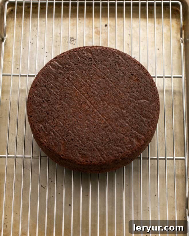 A freshly baked fudge cake being removed from its pan onto a cooling rack after resting.