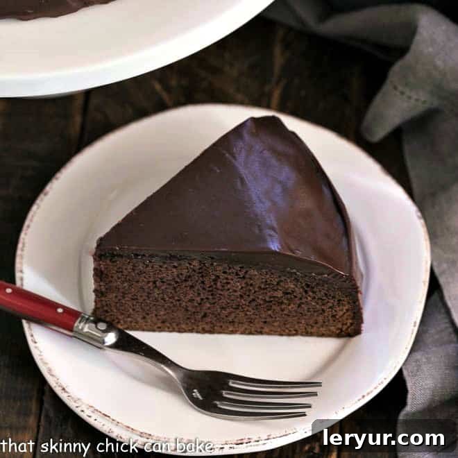 A delectable slice of One Layer Chocolate Cake on a white plate, glistening with ganache