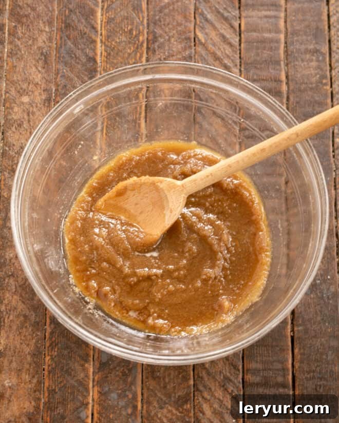 Melted butter and brown sugar being mixed in a bowl, forming the base for the fudge cake batter.