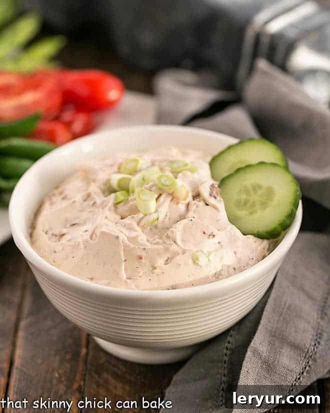 Sun-dried Tomato Dip - an easy, irresistible dip made your food processor! Perfect with sliced veggies or chips! Creamy Sun-dried Tomato Dip garnished with fresh green onions and crisp cucumber slices.