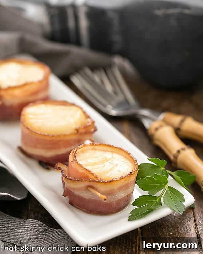 Bacon wrapped scallops on a white tray ready to be served