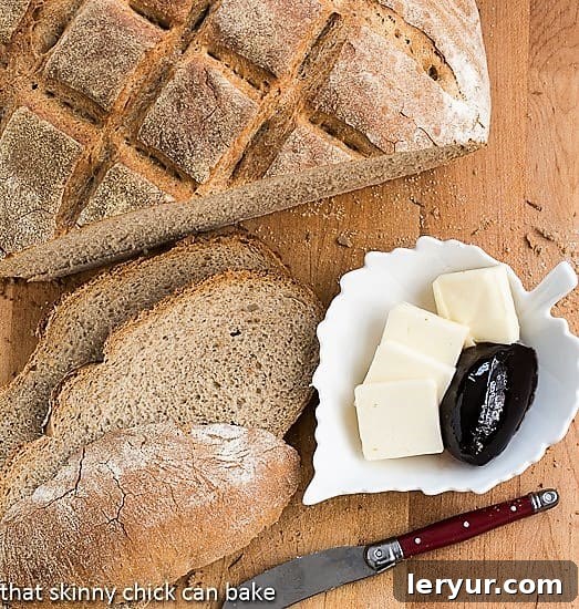 Sliced Country Bread on a cutting board with butter and jelly, ready to be enjoyed