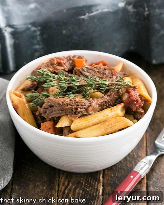 Beef Burgundy pasta in a white bowl with a fork