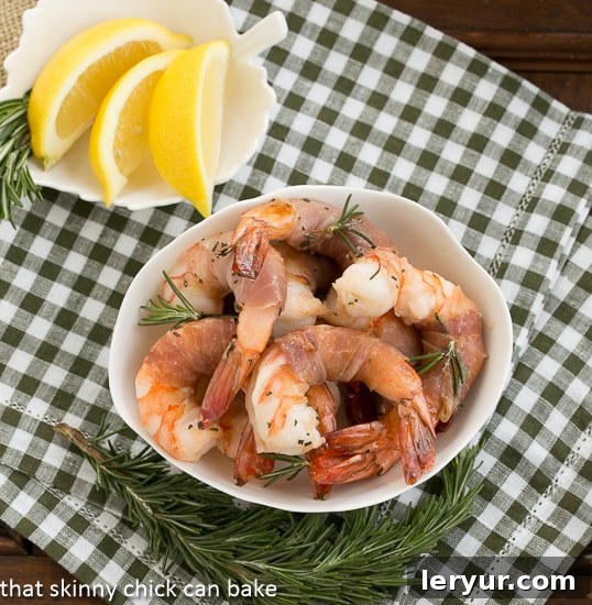Rosemary Prosciutto Shrimp: Succulent, jumbo shrimp wrapped in prosciutto and flavored with rosemary and Sambuca! An overhead view of Rosemary Prosciutto Shrimp in a white bowl, showcasing the vibrant colors and appealing arrangement.