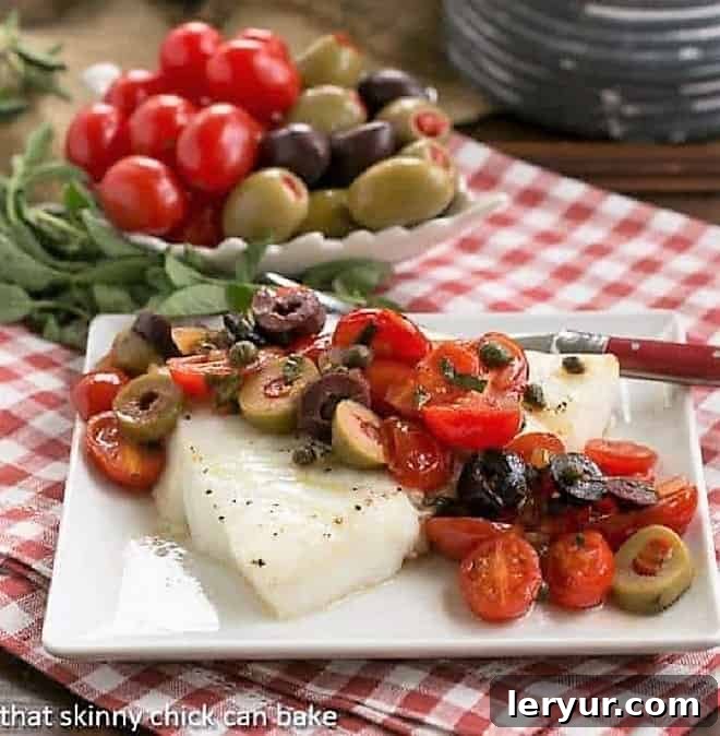 Delicious Sea Bass with Mediterranean Topping - Ready to eat. Close-up of a serving of Mediterranean Baked Sea Bass with Tomatoes, Olives, and Capers on a small square plate, with a fork ready to enjoy.