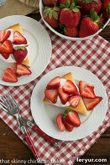 Delectable French Visitandine Cake slices – the ideal French Sponge Cake for elegant strawberry shortcakes Slices of French Visitandine Cake topped with vibrant berries and generous dollops of whipped cream, artfully arranged from an overhead perspective
