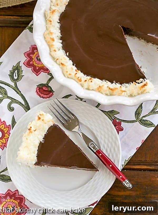 A stunning close-up of a Coconut Crusted Chocolate Ganache Pie with a slice already removed, highlighting the rich, dark chocolate filling and the golden, textured coconut crust.