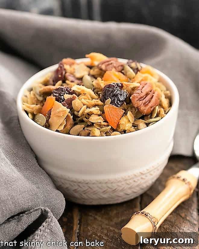 Maple Coconut Granola in a white cereal bowl with a spoon, ready for a delicious start to the day.