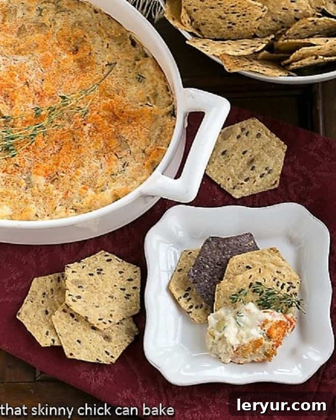 Hot Artichoke Shrimp Dip - A creamy shrimp artichoke appetizer that will be a hit at your next party! Overhead view of Hot Artichoke Shrimp Dip in a casserole dish and on a small serving plate with crackers.