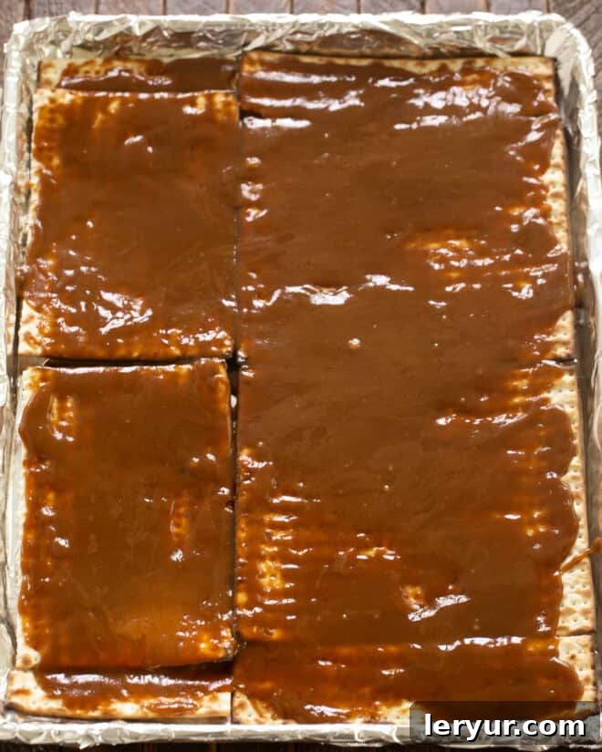 Step 3: Pour the hot caramel mixture evenly over the matzoh layer.