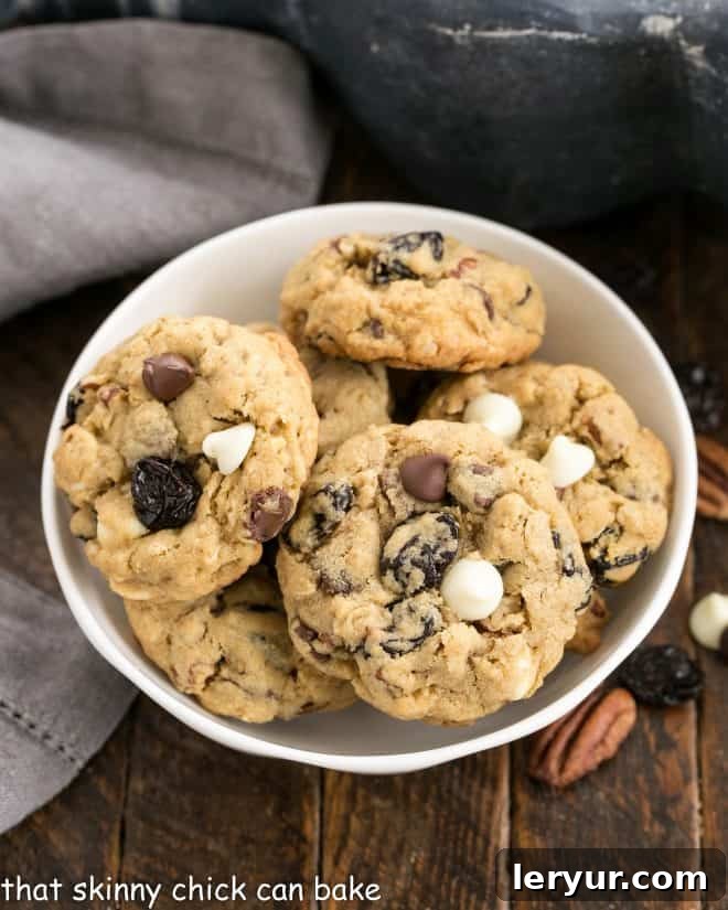 Oatmeal Chocolate Chip Cookies with Dried Cherries - Two kinds of chocolate and dried cherries make these oatmeal cookies irresistible! Overhead view of Oatmeal, Cherry and Chocolate Chip Cookies in a white ceramic bowl