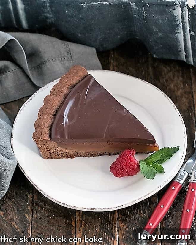 Indulgent Chocolate Caramel Tart 2 Slice of a Chocolate Caramel Tart on a white plate