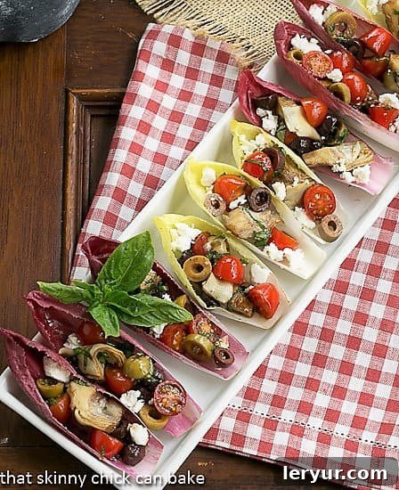 Mediterranean Endive Boats - a fun, bite sized salad or appetizer A tray of Mediterranean Endive Boats arranged on a red and white checked napkin, ready for serving.
