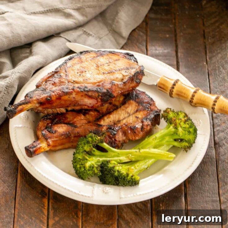 Marinated pork chops with broccoli on a dinner plate, showcasing the delicious outcome of the recipe.