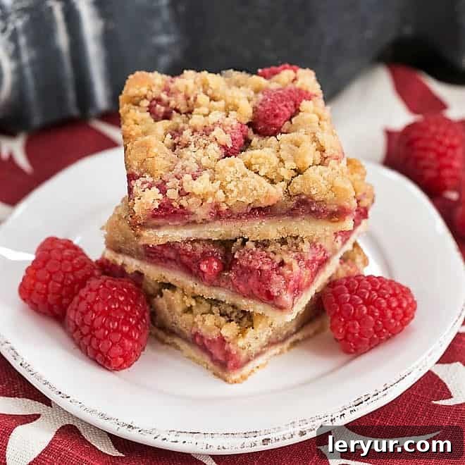 Stack of Streusel Topped Raspberry Cookie Bars on a small round white plate