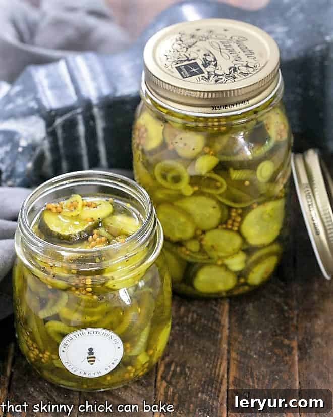 Two jars of Easy Bread and Butter Pickles, one without a lid, showcasing their vibrant color and fresh slices.