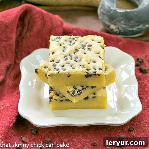 Ultimate White Chocolate Brownies: Dense, Decadent, and Delicious! Stack of rich, dense White Chocolate Brownies on a white dessert plate, ready to be enjoyed.