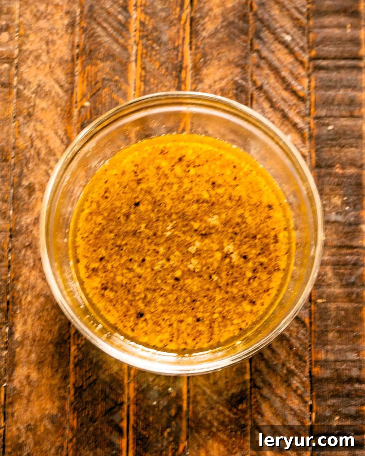 Zesty Mustard Lime Chicken 3 Chicken marinade in a clear glass bowl, showing the mixture of mustards, garlic, and lime.