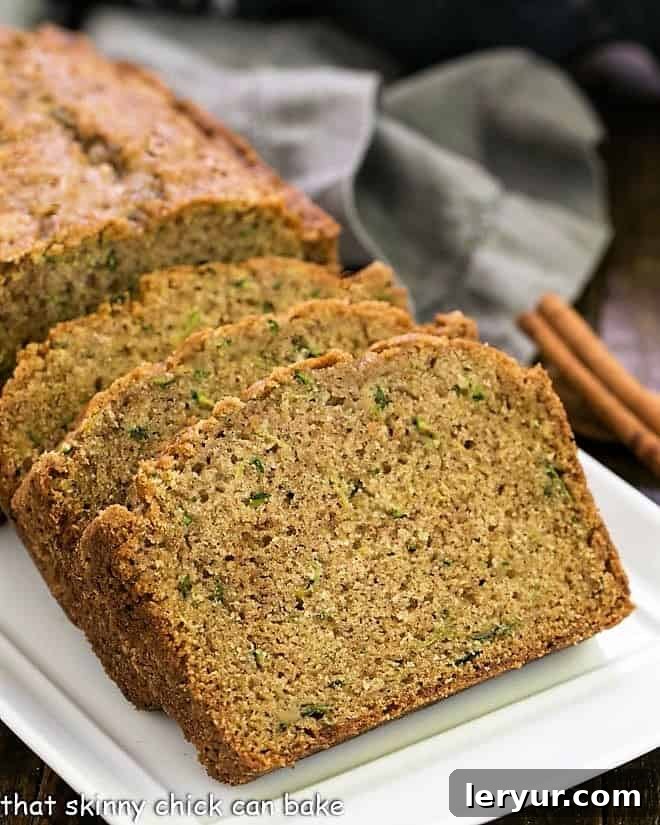 Cinnamon Zucchini Bread is tender, moist with a touch of cinnamon for an irresistible snack, breakfast or even dessert! Cinnamon Zucchini Bread slices on a white tray.