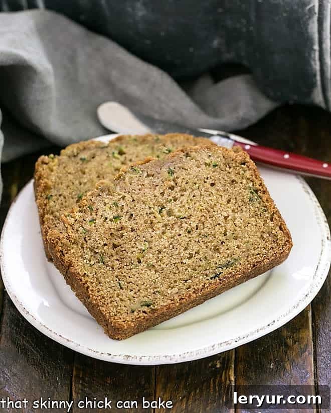 Classic Zucchini Bread is tender, moist with a touch of cinnamon for an irresistible snack, breakfast or even dessert! Zucchini Bread slices on a round white ceramic plate.