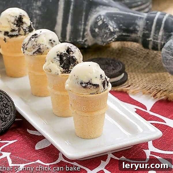 Homemade Oreo Ice Cream - Dreamy homemade ice cream recipe with generous chunks of Oreo cookies! Four mini ice cream cones filled with homemade Oreo Ice Cream, arranged neatly on a white tray, showing off the cookie pieces.