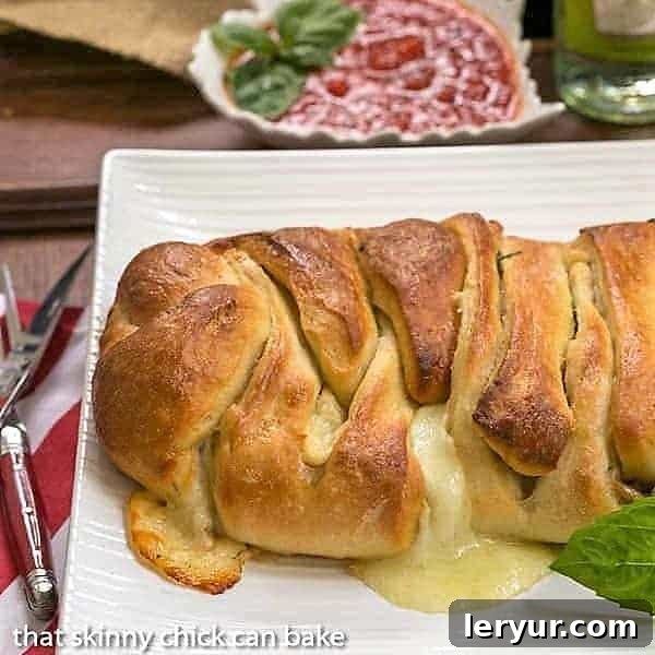 A golden-brown braided stromboli, freshly baked and ready to serve, sits on a rustic white serving tray. Its intricate braid showcases the delicious fillings peeking through. Perfect for sharing at a gathering or enjoying as a special Friday night dinner.