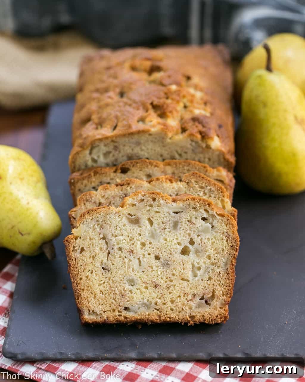 Sour Cream Pear Bread - A delectable autumn quick bread with subtle warm spices and chunks of fresh pears Sliced Sour Cream Pear Bread with whole pears and autumn decorations on a slate tray.