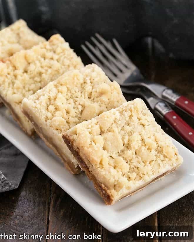 Golden Caramel Squares 2 Golden brown Caramel Butter Bars neatly lined up on a narrow white serving tray, showcasing their layered texture.