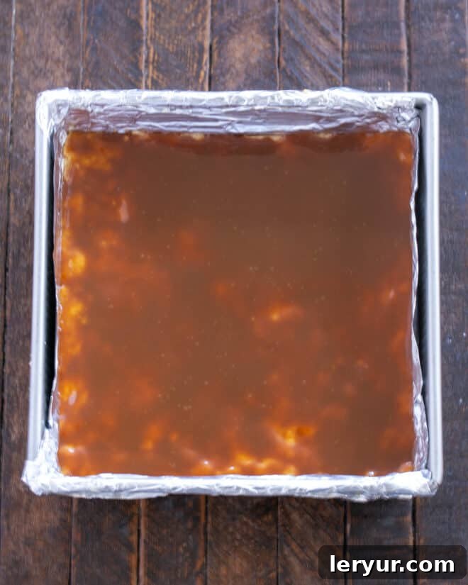 Golden Caramel Squares 9 Caramel sauce is being spread smoothly over the warm crust.