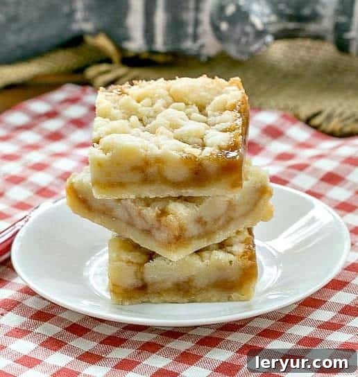 Caramel Butter Bars - Simple flavors with delicious results! Classic Caramel Butter Bars stacked on a small, elegant white round plate, hinting at their rich history.