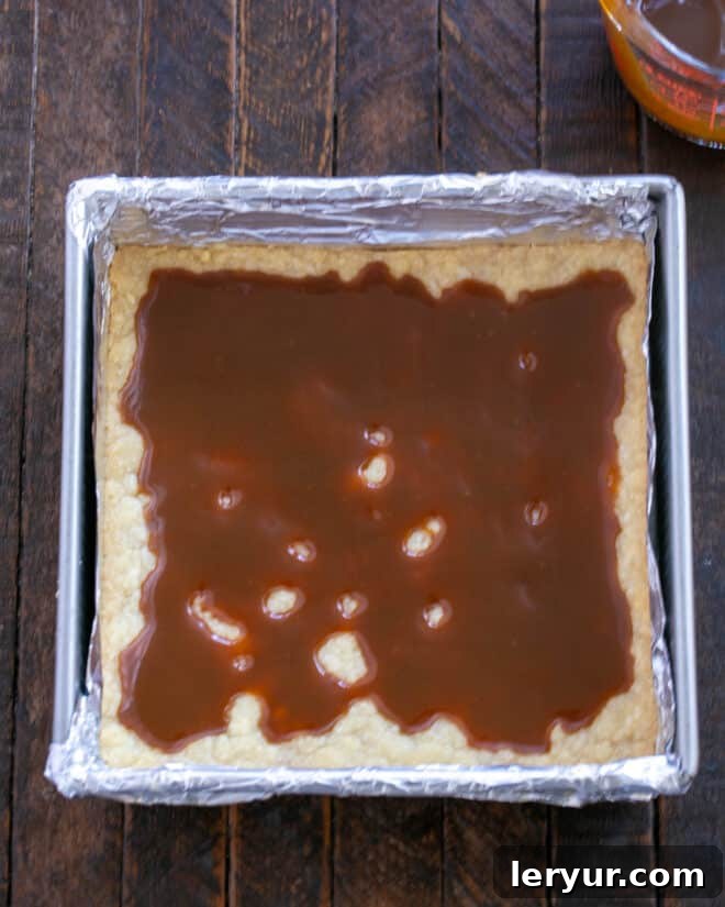 Golden Caramel Squares 8 Caramel sauce is being poured over the hot, baked shortbread crust.