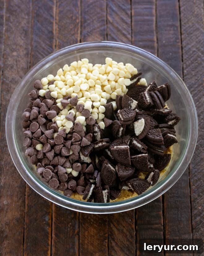 Cookies and Cream Chocolate Chip Bars 7 Folding in chocolate chips and chopped Oreo cookies into the cookie dough.