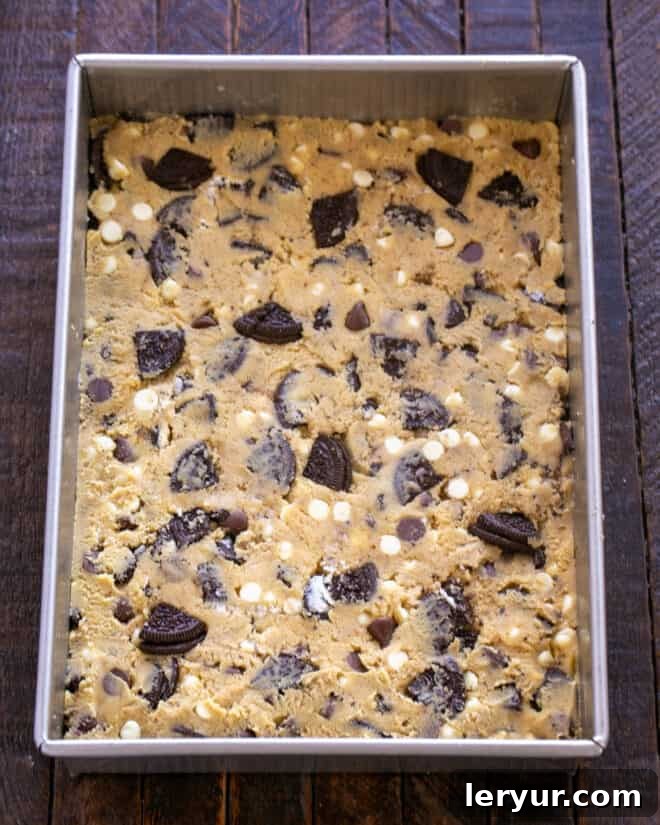 Cookies and Cream Chocolate Chip Bars 8 Spreading the cookie dough evenly into a prepared baking pan.