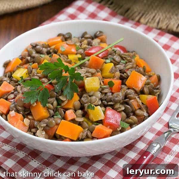 A vibrant French Lentil Salad served in a pristine white bowl, garnished with a sprig of fresh parsley, highlighting its freshness and appeal.