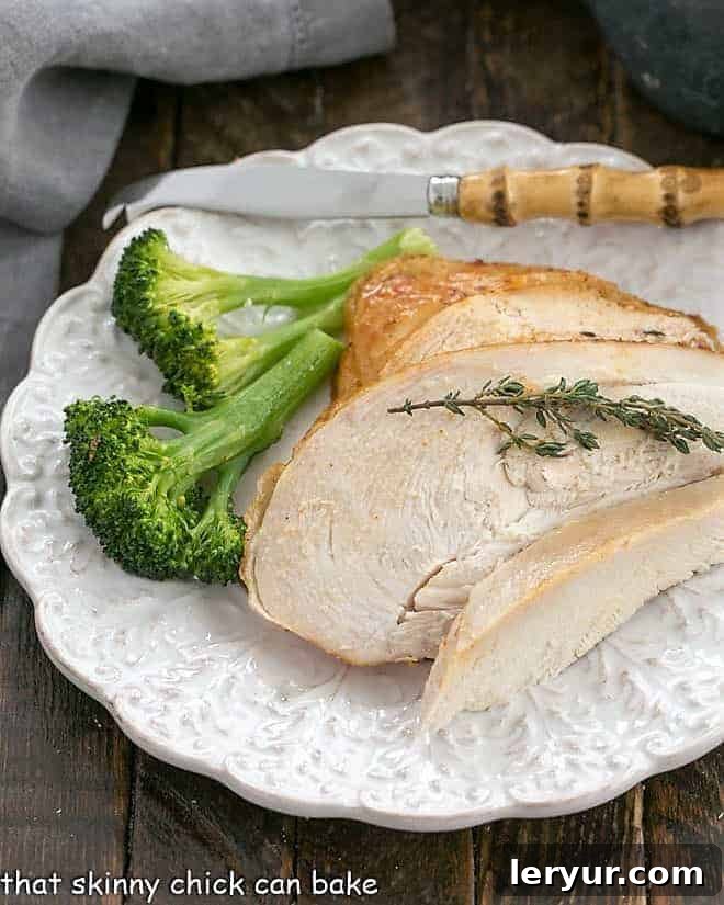 Rotisserie Chicken Perfection 5 Rotisserie Style chicken slices on a white plate with a knife and broccoli spears.