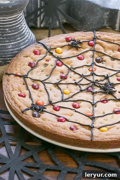 Close-up of a Spiderweb Cookie Cake on a white plate over a black felt spiderweb, highlighting the web design.