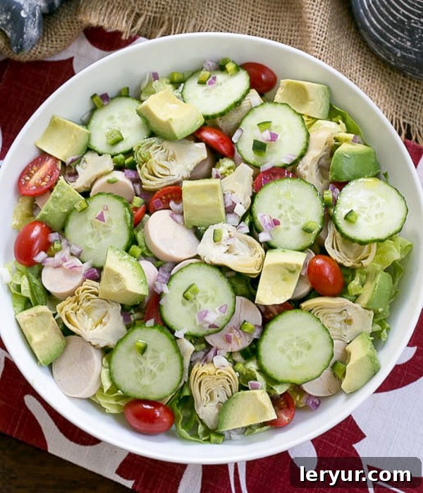 Hearts of Palm, Artichoke, Avocado and Butter Lettuce Salad - an irresistible, refreshing salad! An overhead shot of the Hearts of Palm, Artichoke, Avocado, and Butter Lettuce Salad in a beautiful white serving bowl, showcasing its fresh ingredients.