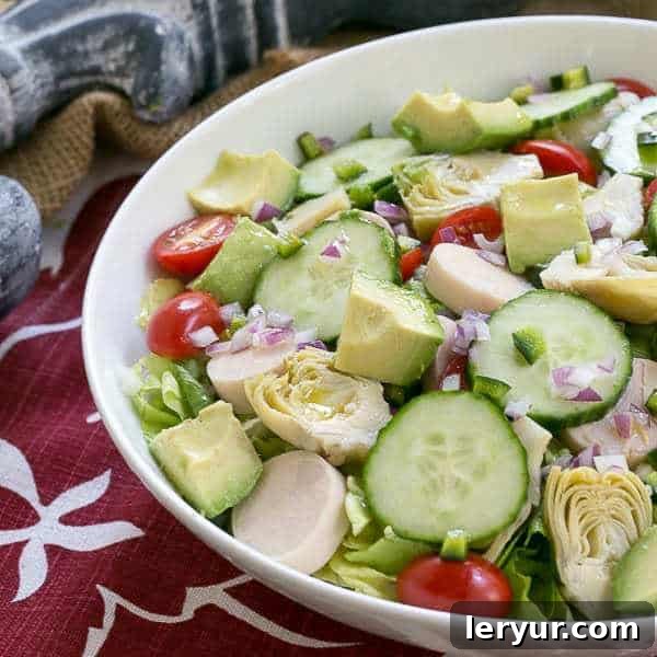 A beautifully presented Hearts of Palm, Artichoke, Avocado and Butter Lettuce Salad in a serving bowl.